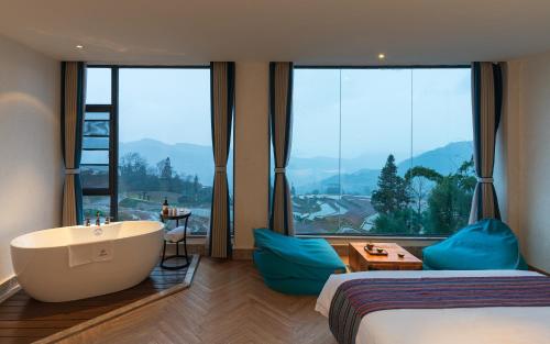 - une chambre avec une baignoire et une grande fenêtre dans l'établissement The Twelve Manor•Terraces Lodge, à Yuanyang