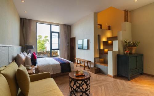 ein Hotelzimmer mit einem Bett und einem Sofa in der Unterkunft The Twelve Manor•Terraces Lodge in Kreis Yuanyang