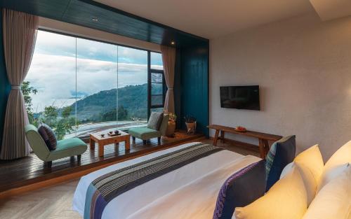 a bedroom with a large bed and a large window at The Twelve Manor•Terraces Lodge in Yuanyang