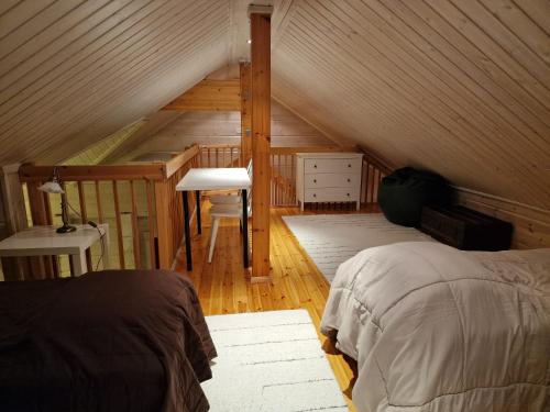 a bedroom with a bed and a desk in a attic at Luvelahti in Aikkila