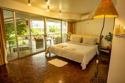 バンコクにあるHome16 Sukhumvit16の白いベッドと大きな窓のある寝室
