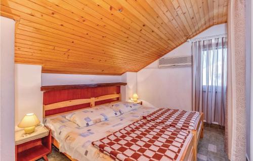 a bedroom with a large bed with a wooden ceiling at Cozy Apartment In Crikvenica With Wifi in Crikvenica