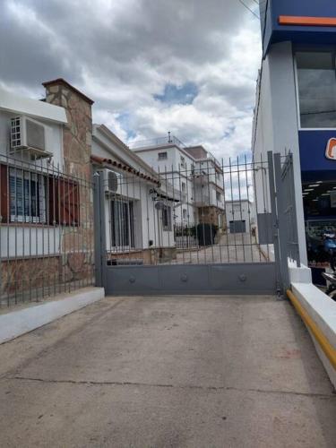 a gate in front of a building with buildings at Balcones del Cerro Mono ambiente céntrico 2p - camas simples in Villa Carlos Paz