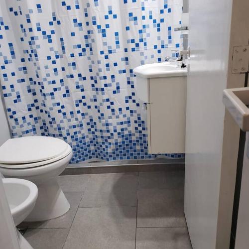 a bathroom with a white toilet and a sink at Balcones del Cerro Mono ambiente céntrico 2p - camas simples in Villa Carlos Paz