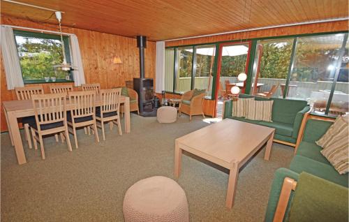 - un salon avec des tables, des chaises et des fenêtres dans l'établissement Holiday Home Blavand With Sauna 294, à Blåvand