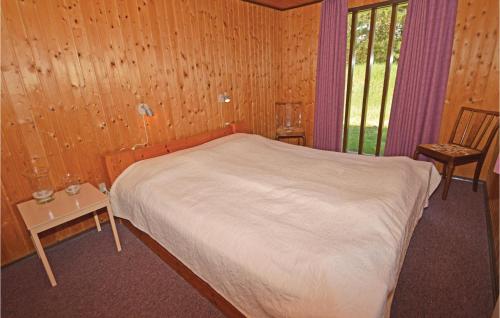 ブラーバンドにあるAmazing Home In Blvand With 3 Bedrooms, Sauna And Wifiのベッドルーム1室(ベッド1台、椅子、窓付)