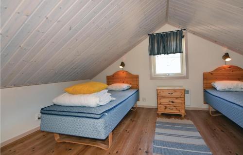 a attic bedroom with two beds and a window at Awesome Home In Slen With 3 Bedrooms, Sauna And Wifi in Sälen