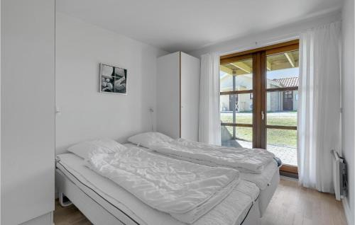 Egernsundにある3 Bedroom Gorgeous Home In Egernsundの白いベッドルーム(ベッド1台、窓付)