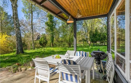 a white table and chairs on a patio with a grill at Awesome Home In Fårevejle With Kitchen in Fårevejle