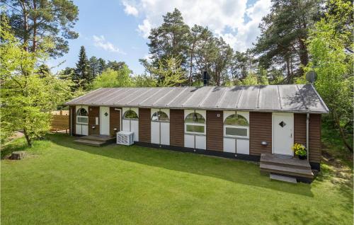a large wooden cabin with white doors and a yard at 4 Bedroom Beautiful Home In Rørvig in Rørvig