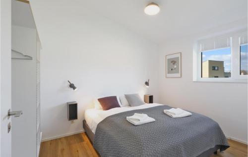 ein weißes Schlafzimmer mit einem Bett und einem Fenster in der Unterkunft Stunning Home In Lembruch-dmmer See With Sauna in Lembruch