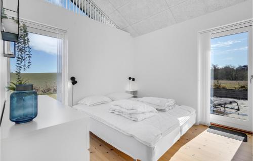 ein weißes Schlafzimmer mit einem weißen Bett und einem Fenster in der Unterkunft Amazing Home In Slagelse With Kitchen in Slagelse