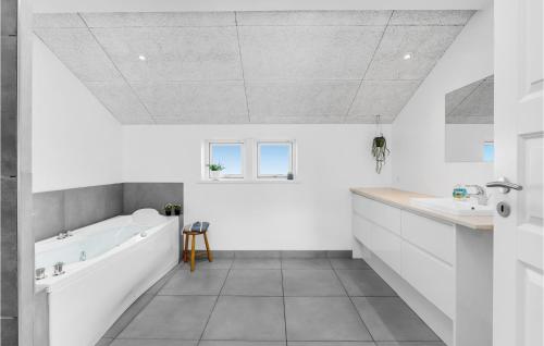 ein weißes Badezimmer mit einer Badewanne und einem Waschbecken in der Unterkunft Amazing Home In Slagelse With Kitchen in Slagelse
