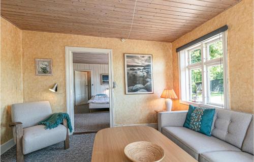 ein Wohnzimmer mit einem Sofa und einem Tisch in der Unterkunft Risegrd, Lejl, A in Åkirkeby