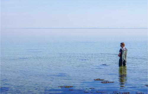 a woman standing in the water in the ocean at Four-Bedroom Holiday Home In Haderslev in Haderslev