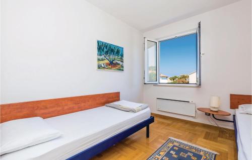 a bedroom with a bed and a window at Nice Apartment In Barbat With 2 Bedrooms And Wifi in Barbat na Rabu