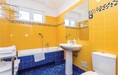 a yellow bathroom with a sink and a toilet at Nice Apartment In Barbat With 2 Bedrooms And Wifi in Barbat na Rabu