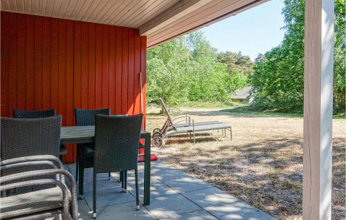 a patio with a table and chairs and a bench at 3 Bedroom Gorgeous Home In Aakirkeby in Vester Sømarken