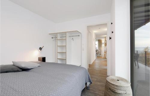 ein weißes Schlafzimmer mit einem Bett und einem Balkon in der Unterkunft Nice Apartment In Lembruch-dmmer See With Kitchen in Lembruch