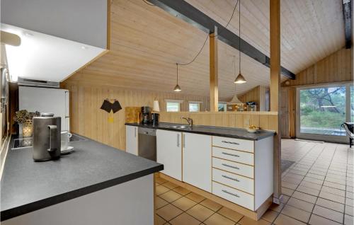 a kitchen with white cabinets and a counter top at Holiday Home Ringvejen Iii in Rømø