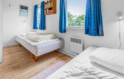 Venemose的住宿－Lovely Home In Slagelse With Wifi，一间卧室设有两张床,窗户配有蓝色窗帘