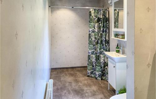 y baño con cortina de ducha y lavamanos. en Nice Home In Boxholm With Kitchen, en Boxholm