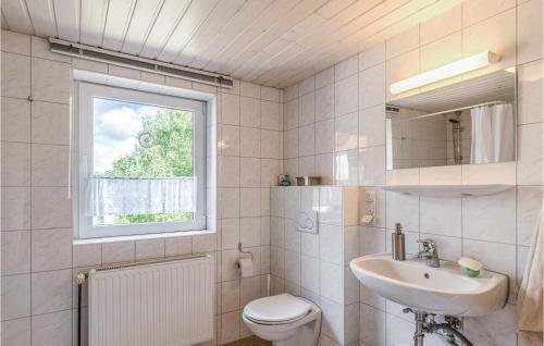 a bathroom with a sink and a toilet and a window at 2 Bedroom Stunning Home In Lehe in Lehe