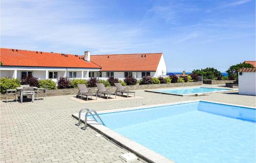 a swimming pool in front of a house at Cozy Apartment In Gudhjem With Wifi in Gudhjem