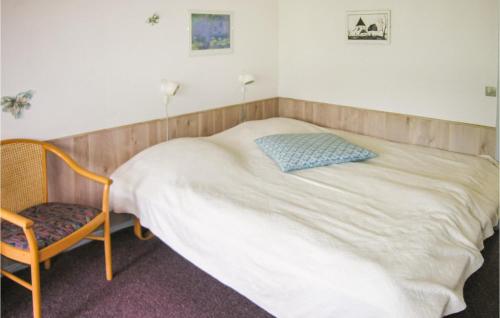 1 dormitorio con 1 cama y 1 silla en Nice Apartment In Nex With Outdoor Swimming Pool, en Bedegård