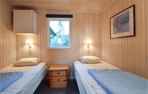 two twin beds in a room with a window at Nice Home In Rm With House Sea View in Rømø Kirkeby