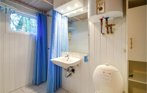 a bathroom with a sink and a toilet and a window at Nice Home In Rm With House Sea View in Rømø Kirkeby