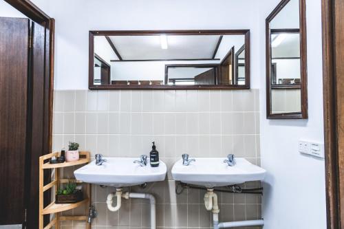 a bathroom with two sinks and a mirror at Unwind Escapes Cabins & Glamping in Dooralong