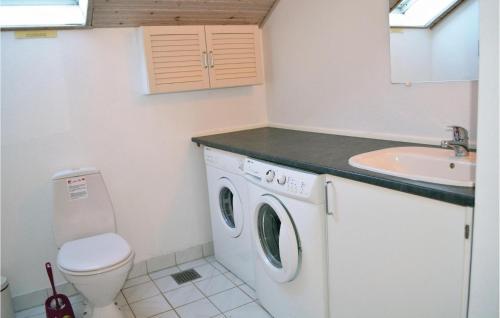 een badkamer met een wasmachine en een wastafel bij Pet Friendly Home In Henne With Sauna in Henne Strand