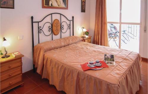 1 dormitorio con 1 cama con 2 tazas sobre una mesa en 2 Bedroom Awesome Apartment In Nerja, en Nerja