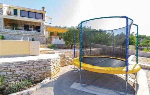 een trampoline in een tuin naast een huis bij Amazing Home In Tankaraca With 4 Bedrooms, Wifi And Outdoor Swimming Pool in Vela Luka