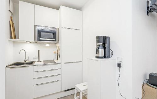a kitchen with white cabinets and a microwave at Pet Friendly Apartment in Lembruch