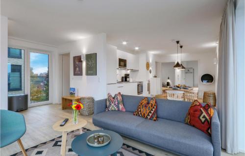 レンブルッフにあるNice Apartment In Lembruchdümmer Seeの青いソファとキッチンのあるリビングルーム