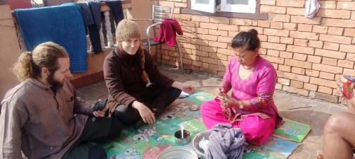 a group of three people sitting on the ground at Laxmi Homestay with main square view in Bhaktapur