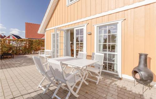 a patio with a table and chairs and a vase at Holiday Home Strandgårdsvej Iv in Bro