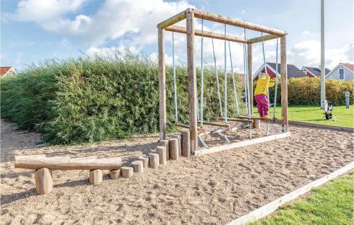 a person on a swing set in a park at Holiday Home Strandgårdsvej Iv in Bro