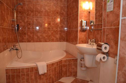 a bathroom with a tub and a sink and a toilet at Hotel Albertin in Berlin