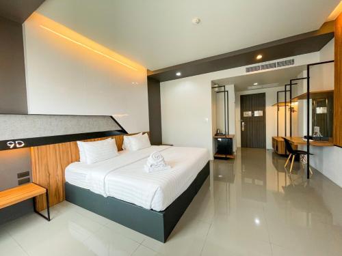 a bedroom with a large bed and a desk at 9D Sport Hotel in Udon Thani