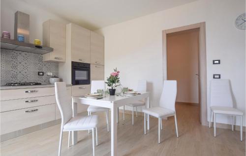 a white kitchen with a white table and chairs at La Casa Rossa in Framura