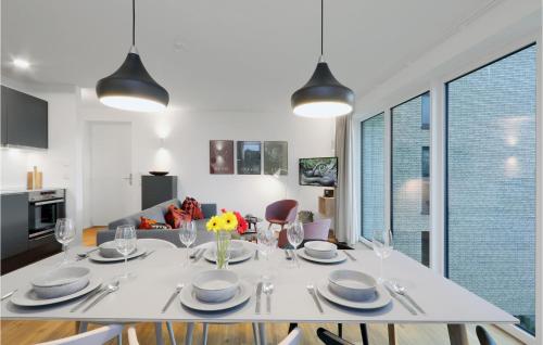 ein weißes Esszimmer mit einem weißen Tisch und Stühlen in der Unterkunft Beach Front Apartment in Lembruch