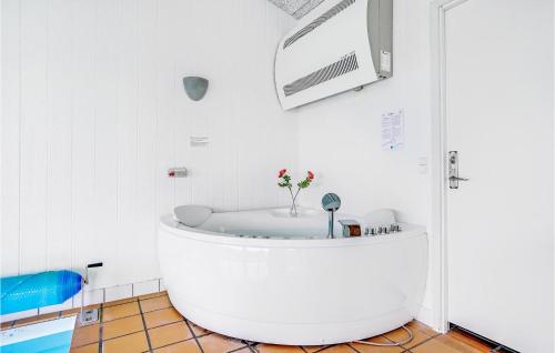 Habitación con baño blanco con bañera. en Lovely Home In Knebel With House Sea View en Skødshoved Strand