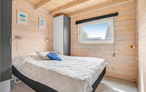 ein Schlafzimmer mit einem Bett in einer Holzwand in der Unterkunft Lovely Home In Knebel With House Sea View in Skødshoved Strand