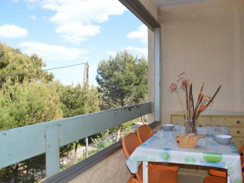 un balcon avec une table et des chaises et une grande fenêtre dans l'établissement Appartement à 200m de la plage, 2 pièces cabine, 6 couchages, loggia, parking, quartier calme - FR-1-229B-138, à Narbonne