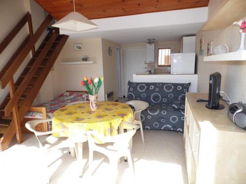 une cuisine avec une table avec un vase de fleurs dessus dans l'établissement Duplex 2 pièces avec terrasse, parking privé et tout équipé pour 4 personnes - FR-1-326-451, à Marseillan