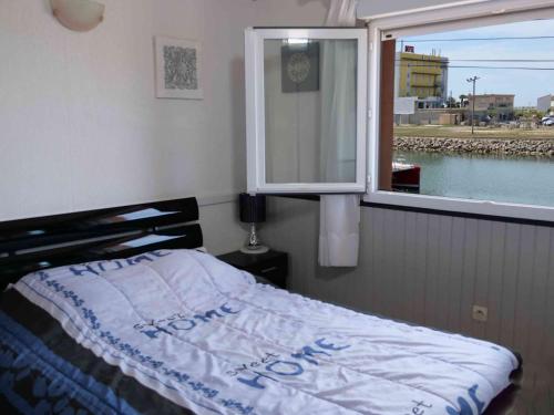 - une chambre avec un lit en face d'une fenêtre dans l'établissement Maison climatisée avec parking et terrasses, 2 chambres, quartier calme - FR-1-387-68, à Marseillan