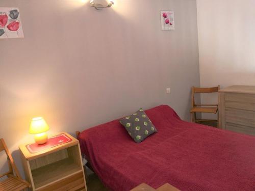 - une chambre avec un lit rouge et une lampe sur une table dans l'établissement Appartement studio cabine mezzanine, 4-6 couchages, parking privé, proche plage - FR-1-326-592, à Marseillan